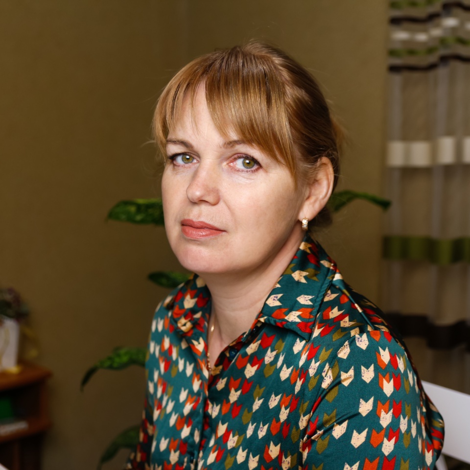 Portrait of elegant mature woman wearing blouse and looking at camera. Closeup of confident woman sitting at home office. Successful lady indoor. Blonde lady.