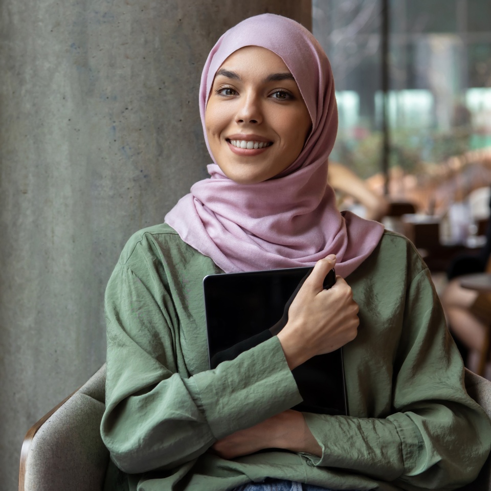 Young woman in hijb with a laptop in hands