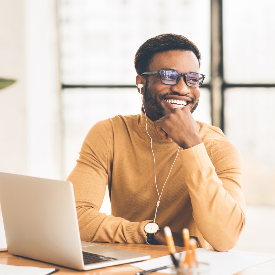 Time To Relax. Satisfied afro man in headphones listening to music in office, looking aside, free space