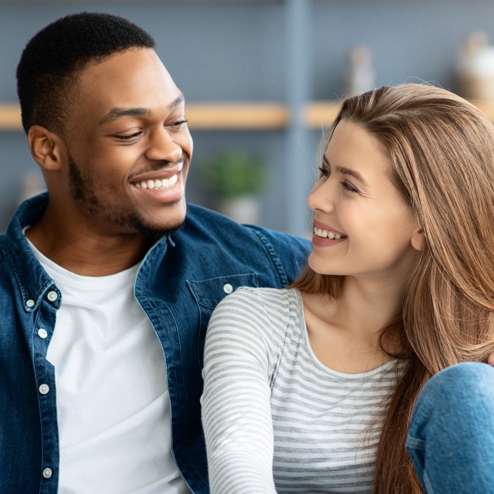 Portrait Of Loving Interracial Couple Relaxing Together At Home