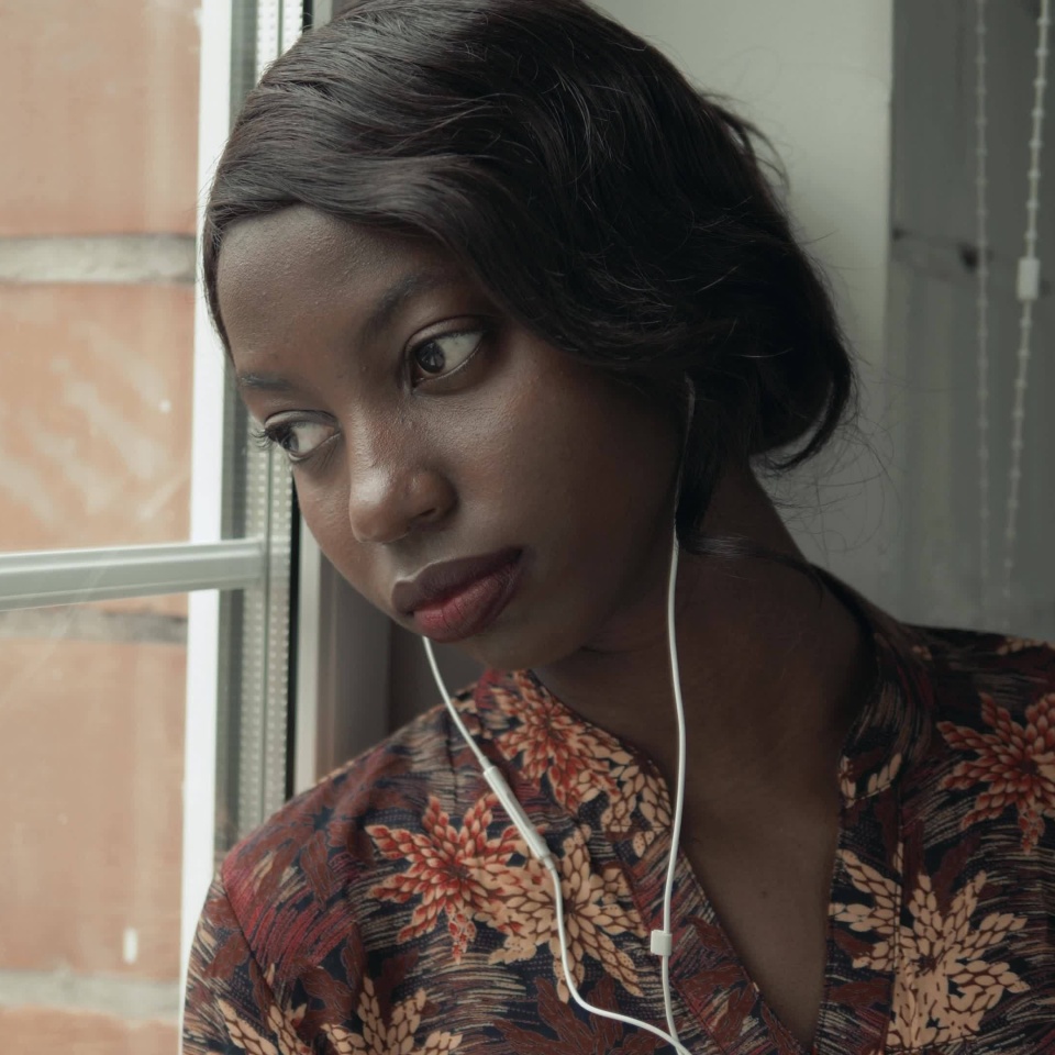 Young black woman listening music travelling looking outdoor the window, pensive - thoughtful, thinking future, music concept, african american student think about home